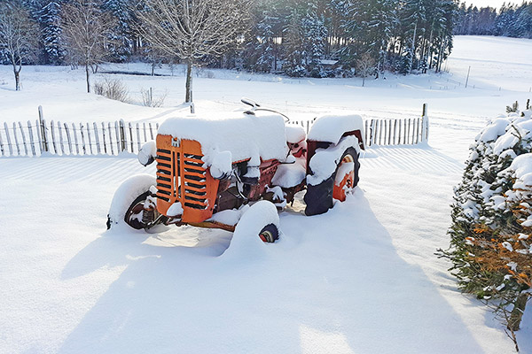 Der alte Traktor hat eine dicke Schneehaube